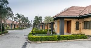 an empty street with houses and palm trees at Fallsway Villas in Lusaka