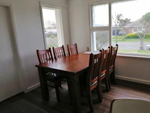 un tavolo in legno con sedie in una stanza con finestra di Homestay Double room, near the city center a Christchurch