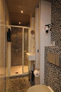 a bathroom with a shower and a toilet and a sink at B&B de Valkenhorst in Lelystad