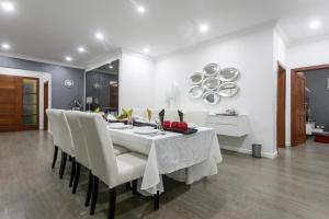 a dining room with a white table and white chairs at Fallsway Villas in Lusaka