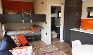 a living room with a couch and a bunk bed at Wild Atlantic Camp in Creeslough +24 photos