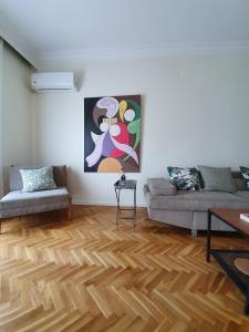 sala de estar con sofá y suelo de madera en Urban Deluxe Apartments, en Tesalónica