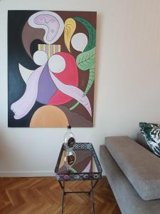 uma sala de estar com uma mesa e um quadro na parede em Urban Deluxe Apartments em Tessalônica