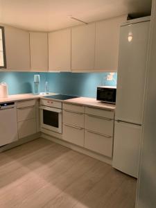 a kitchen with white cabinets and a refrigerator at Beautiful apartment in central Leknes in Leknes +8 photos