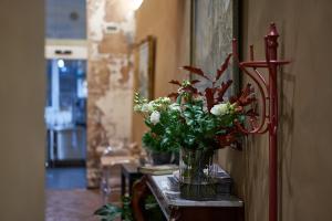 a vase of flowers on a table in a room at Locanda delle Mercanzie in Brescia