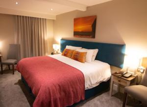 a hotel room with a large bed with a red blanket at The Marine Boutique Hotel in Ballybunion