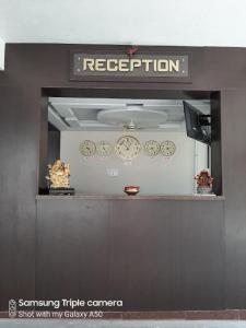 um balcão de recepção com relógios na parede em Viswa Residency by Azalea em Madurai