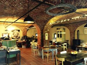 a restaurant with brick walls and tables and chairs at MARSAM locanda in Bene Vagienna