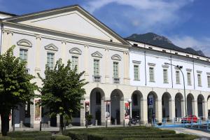 a large white building with a mountain in the background at B&b al Borgo in Lovere
