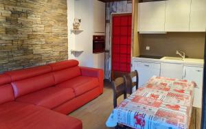 salon z czerwoną kanapą i stołem w obiekcie Le Serac W6 appartement avec véranda en angle vue panoramique gérer par particulier sur place w Val Thorens