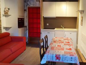 kuchnia ze stołem i czerwoną kanapą w obiekcie Le Serac W6 appartement avec véranda en angle vue panoramique gérer par particulier sur place w Val Thorens