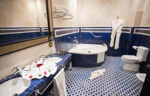 a bathroom with a sink and a tub and a toilet at Palais Dar Si Aissa ALL-SUITES in Marrakesh