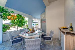 a kitchen and dining room with a table and chairs at Apartments Plavi Biser in Šibenik