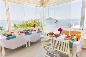 a table with food on it in a room with windows at Kortan Hotel in Turgutreis