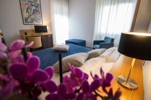 ein Wohnzimmer mit einem Bett und lila Blumen in der Unterkunft Hotel Clarici in Spoleto