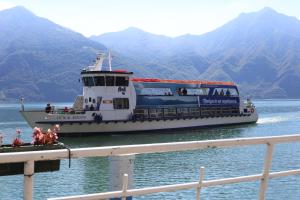 a ferry boat on the water with mountains in the background at B&b al Borgo in Lovere