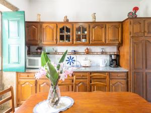 蓬蒂迪利馬的住宿－Holiday Home in Arcozelo with private terrace，厨房配有木制橱柜和花瓶上的花桌
