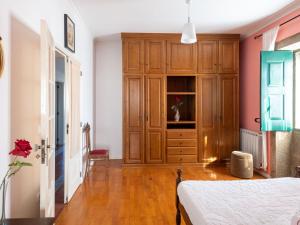sypialnia z drewnianą szafką i łóżkiem w obiekcie Holiday Home in Arcozelo with private terrace w mieście Ponte de Lima
