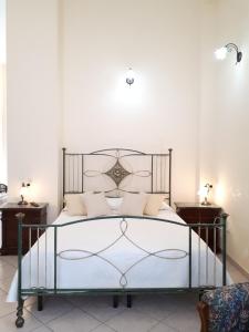 a bedroom with a large bed with white walls at Casa Mia Apartment in Riposto