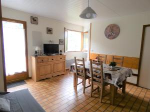 un soggiorno con tavolo, sedie e TV di Le refuge de la Marmotte, Chalets du Bayle a Cauterets