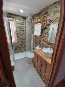 a bathroom with a shower toilet and a sink at Casa Lolola in Sada