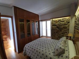 a bedroom with a bed and a stone wall at Casa Lolola in Sada