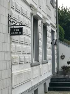 een straatbord aan de zijkant van een gebouw bij B&B Holset70 in Lemiers