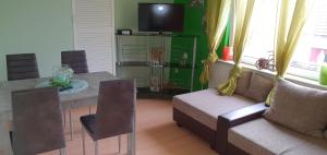 ein Wohnzimmer mit einem Tisch, einem Sofa und einem TV in der Unterkunft Sonnige Ferienwohnung WHV in Wilhelmshaven