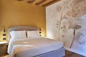 a bedroom with a bed and a painting on the wall at Locanda delle Mercanzie in Brescia