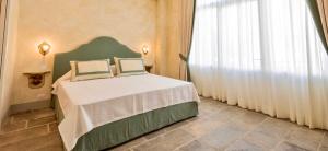 a bedroom with a bed and a large window at Palazzo Mantua Benavides Suites & Apartments in Padova