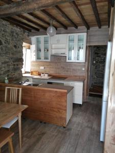 a kitchen with white cabinets and a wooden floor at Casa Lolola in Sada