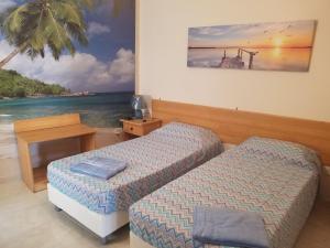 una camera con due letti e una foto dell'oceano di Mulino Court, Flat 5 a Nadur