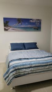 1 dormitorio con 1 cama con 4 cuadros en la pared en Aldeia dos reis - Condado - Mangaratiba - Loft 405 bl 3, en Mangaratiba