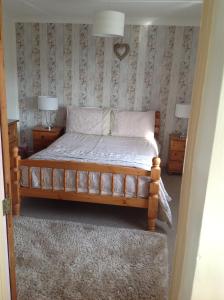 a bedroom with a bed with two night stands and two lamps at Tyisha in Cardigan
