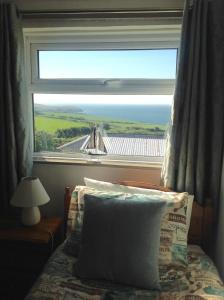 a bedroom with a window with a view of the ocean at Tyisha in Cardigan