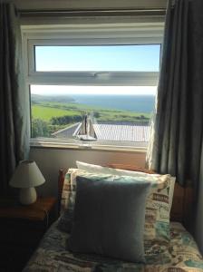 a bedroom with a window with a view of the ocean at Tyisha in Cardigan +10 photos