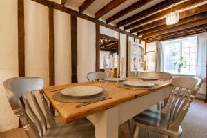a dining room with a wooden table and chairs at Primrose Cottage at The Shippe in Bridge
