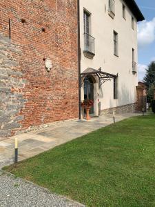 - un grand bâtiment en briques avec une porte et une fenêtre dans l'établissement Castello La Rocchetta, à Sandigliano
