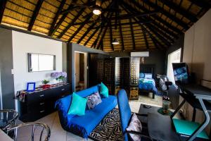 sala de estar con sofá azul y dormitorio en John-Lou's Studio Flat en Windhoek