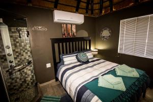 a bedroom with a large bed and a shower at John-Lou's Studio Flat in Windhoek