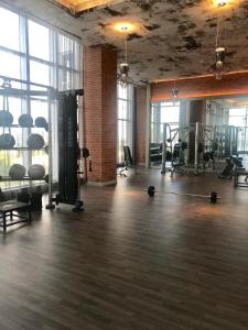 un gimnasio con cintas de correr y equipamiento en una habitación con ventanas en Hide House, en Hollywood