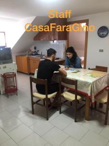 Ein Mann und eine Frau sitzen an einem Tisch in einer Küche in der Unterkunft Casa Fara Gino in Ascoli Piceno
