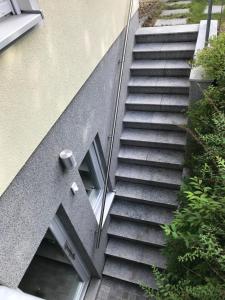 a set of stairs next to a building with a window at Helle Souterrainwohnung mit Komfort in Munich +2 photos