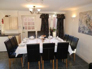 a dining room table with a white tablecloth and black chairs at Hamlet Cottage sleeps 3-4 Stratford upon Avon in Stratford-upon-Avon