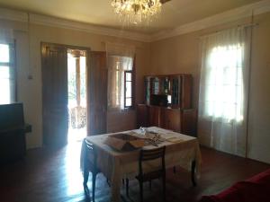 a dining room with a table and chairs and a chandelier at 9 Plus - Orbeli in Orbeli