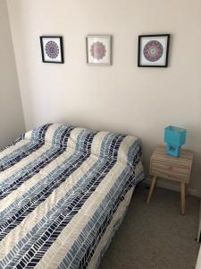 a bedroom with a bed and three pictures on the wall at Departamento Nuevo in El Tabo