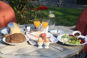 een houten tafel met eten en drinken erop bij Bed & Breakfast Op 't Leven in Ermelo