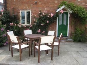 a wooden table and chairs in front of a building at Falstaff Cottage for up to 5, Stratford upon Avon in Stratford-upon-Avon