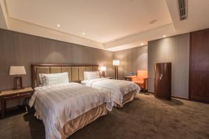 um quarto de hotel com duas camas com lençóis brancos em Royal Biz Taipei Hotel em Taipei