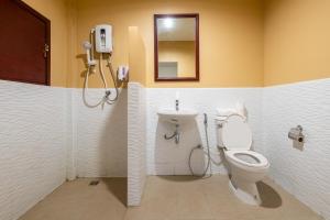 a bathroom with a toilet and a phone on the wall at Scala Hostel in Bangkok